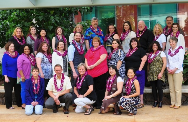 Group of people posing all wearing leis