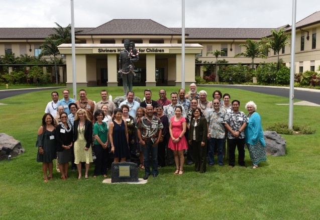 Large group of people posing on grassy lawn