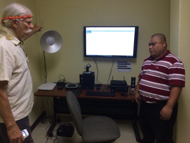 Two men in room looking at computer screen