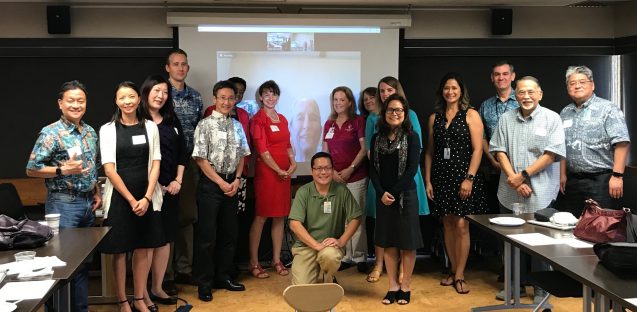 Group of people posing in front of projector