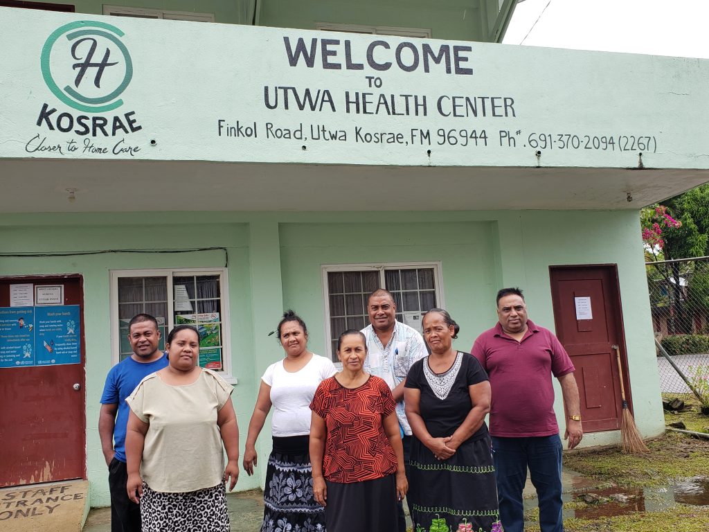 People posing in front of health center