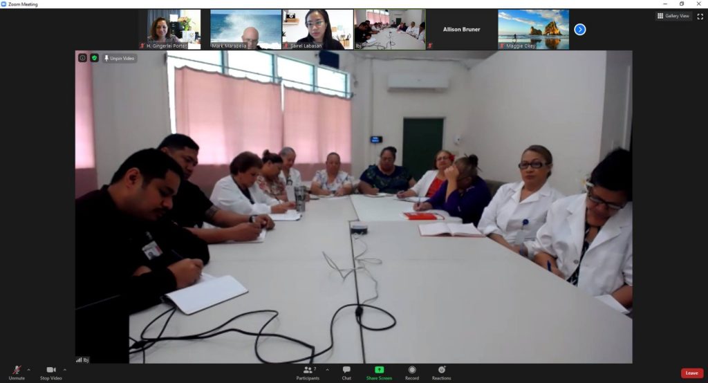 Zoom screenshot of a table with a group of people in white coats sitting at it